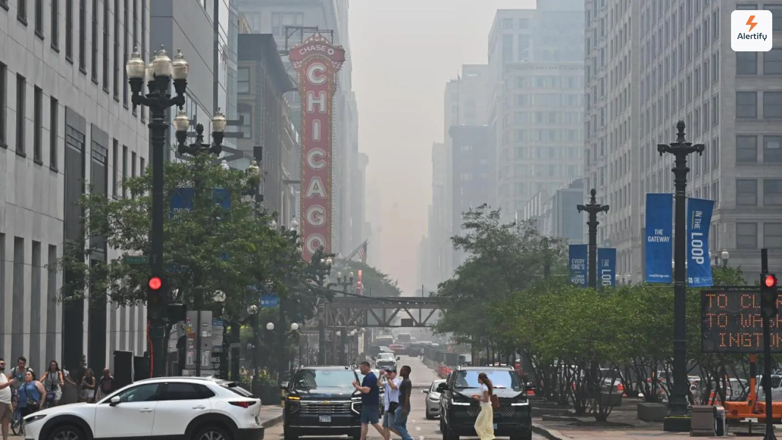 Waldbrand-Dunst verschluckt die Gebäude einer Chicagoer Straße, im Vordergrund leuchtet das Schild des Chicago Theatre.