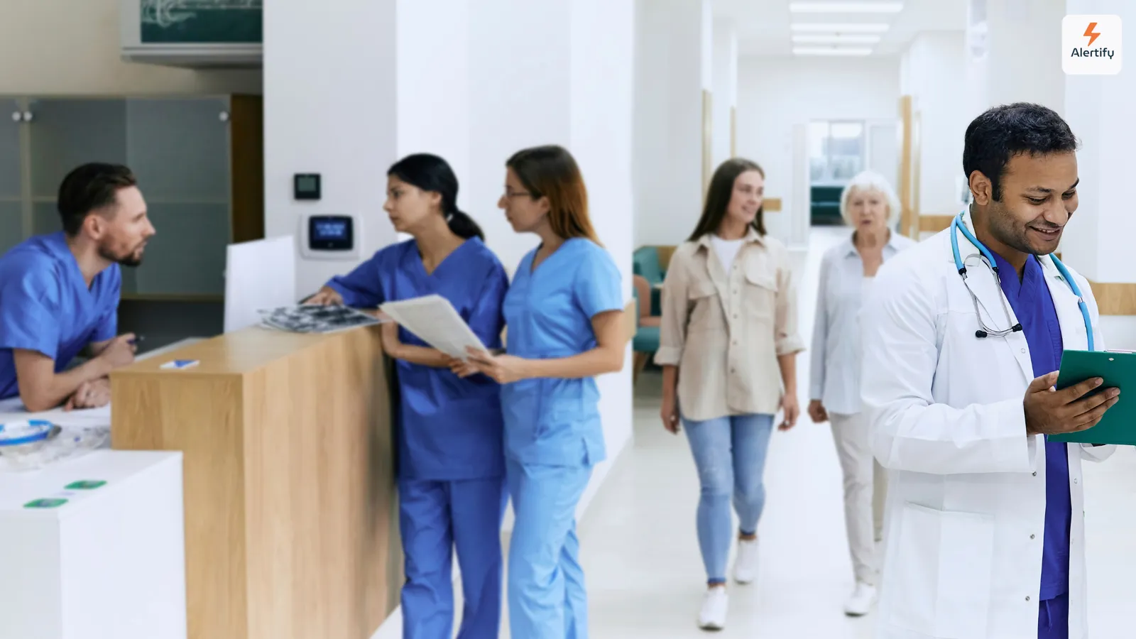Klinikpersonal und Besucher gehen in einer hellen Krankenhaus-Eingangshalle am Empfangstresen vorbei